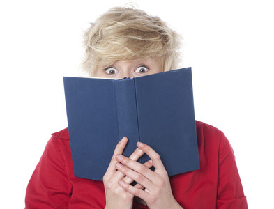 Surprised woman reading a romance novel